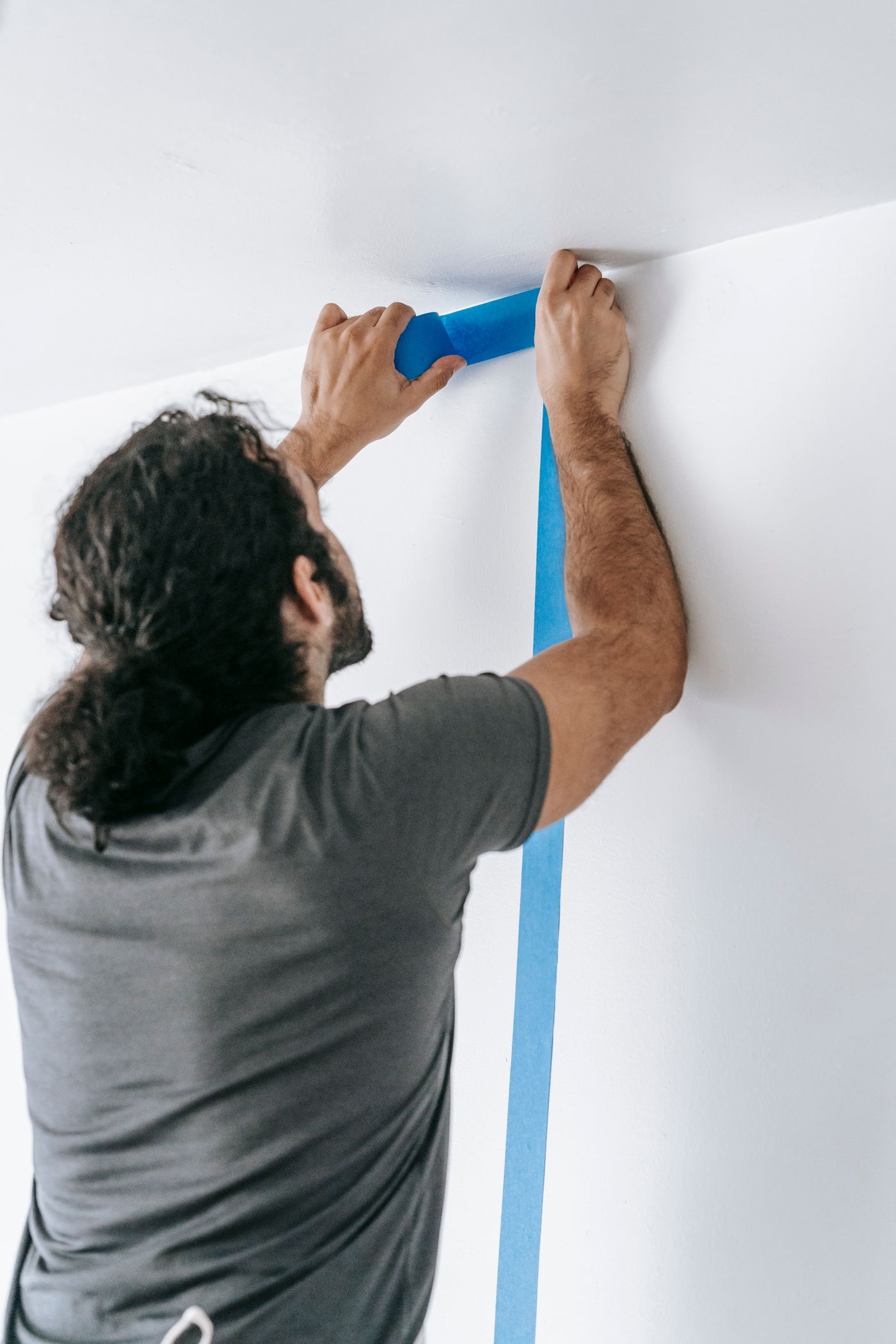 Installer carefully protecting wall edges with painter’s tape before work begins